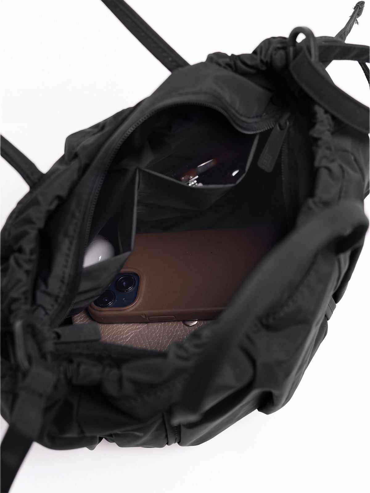 SHELLY BUCKET BAG Tasche in black (Schwarz) Innenansicht mit Gegenständen.