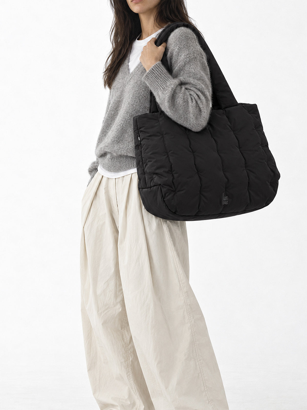 LOOMI HORIZON TOTE BAG Tasche in black (Schwarz) von einer Frau über der Schulter getragen.