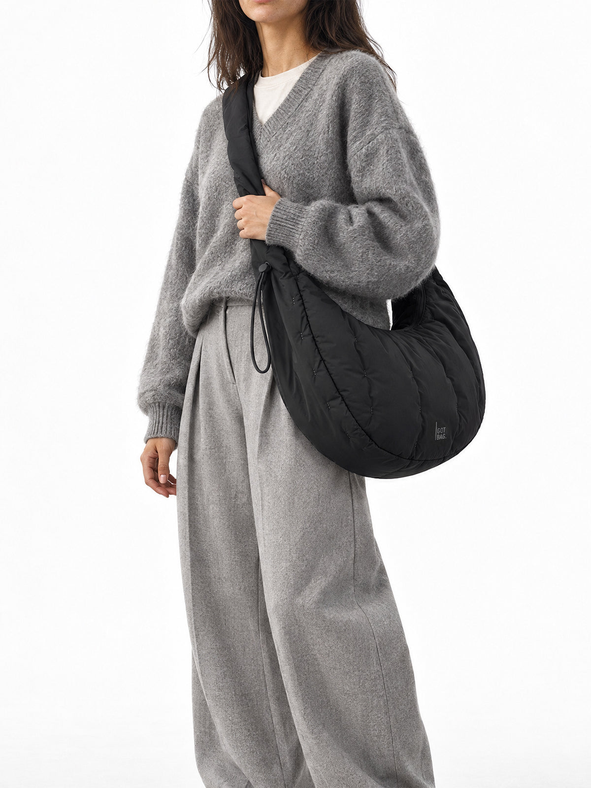 LOOMI MOON BAG RUFFLE Tasche in black (Schwarz) von einer Frau crossbody getragen.