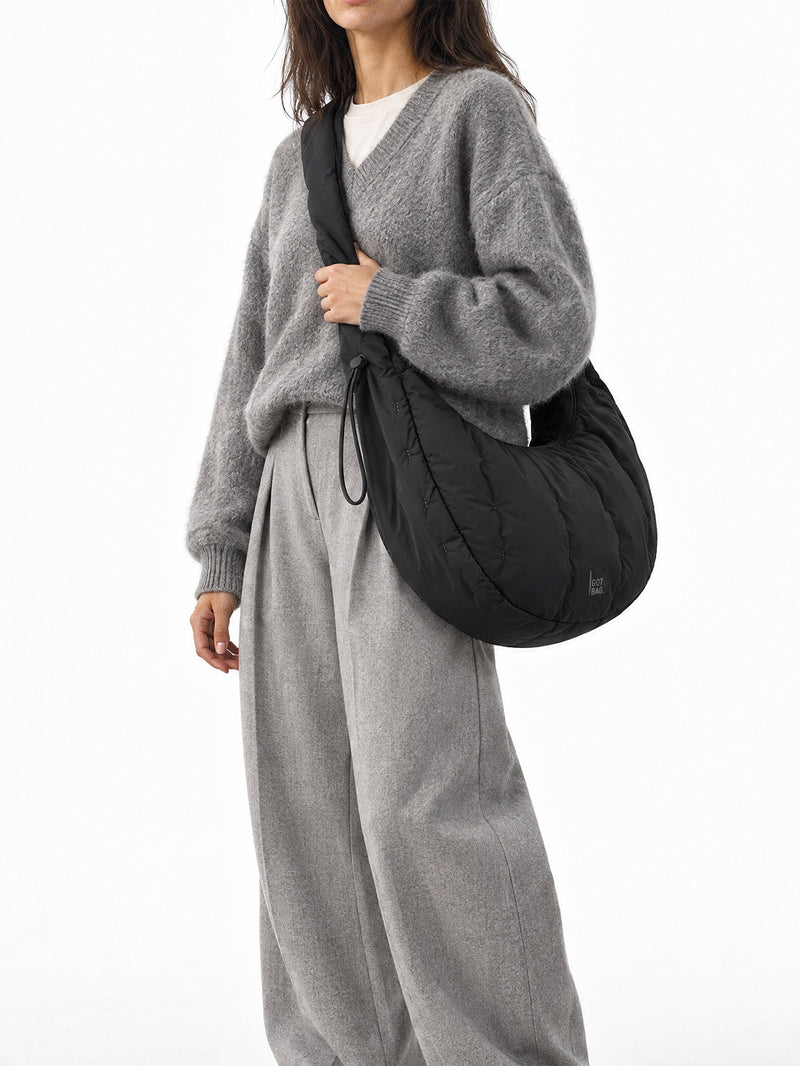 LOOMI MOON BAG RUFFLE Tasche in black (Schwarz) von einer Frau crossbody getragen.