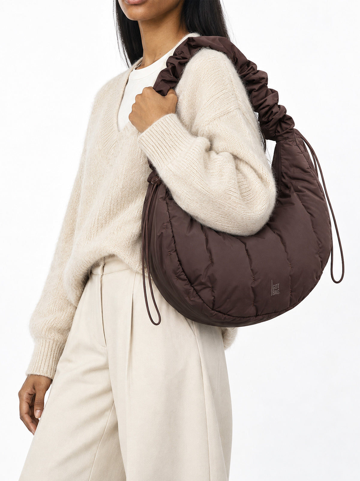 LOOMI MOON BAG RUFFLE Tasche in sea lion (dunkles Schokobraun) von einer Frau über der Schulter getragen.