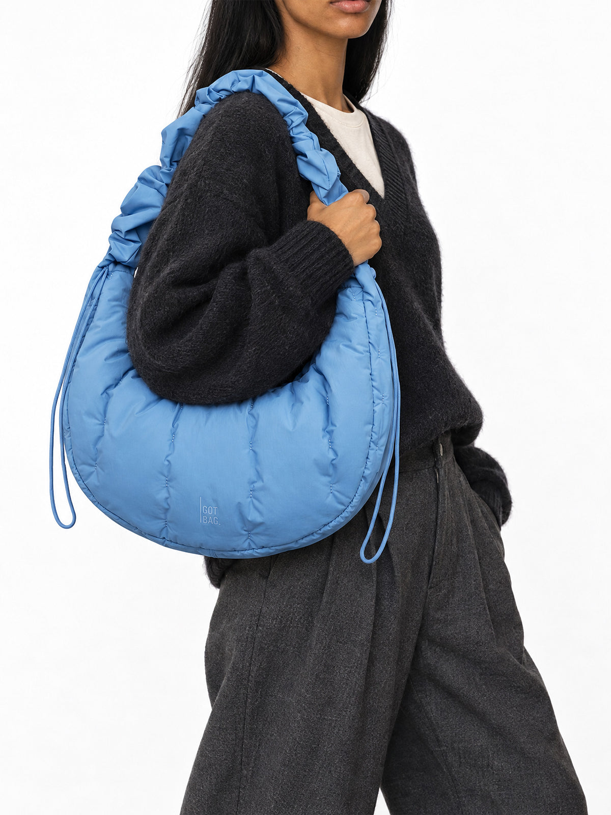 LOOMI MOON BAG RUFFLE Tasche in indigo wave von einer Frau über der Schulter getragen.