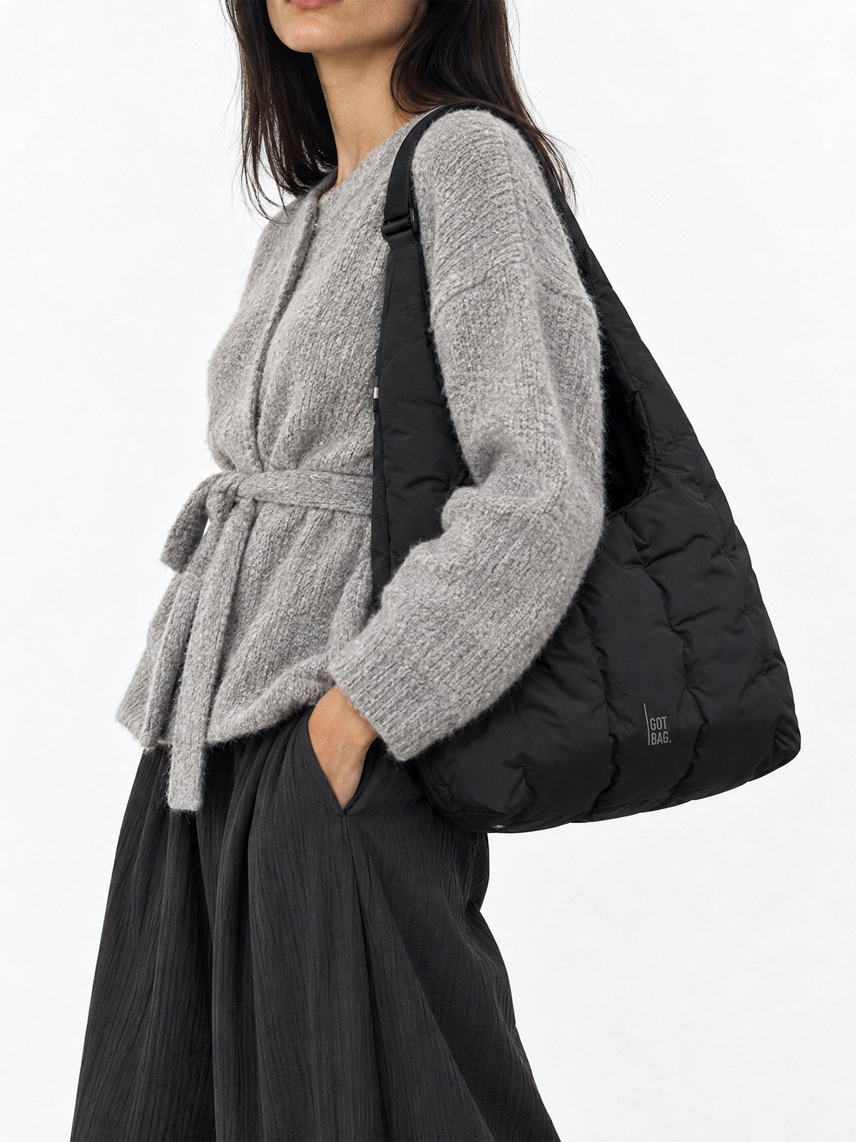 LOOMI SHOULDER BAG Tasche in black (Schwarz) von einer Frau über der Schulter getragen.