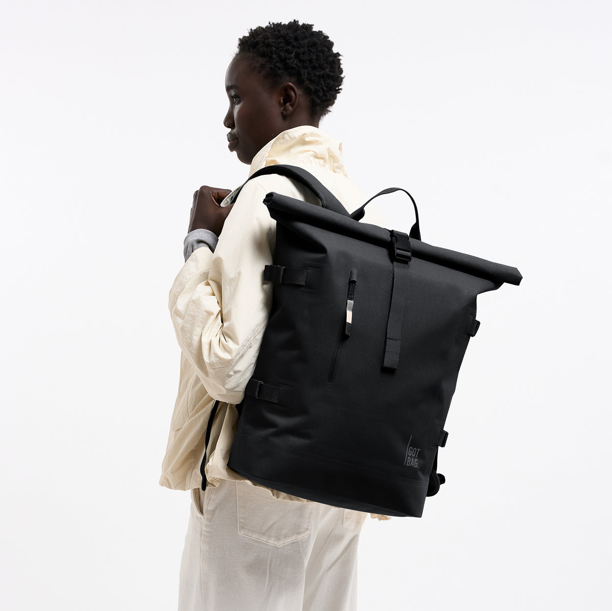 ROLLTOP Rucksack in black (Schwarz) von einer Frau auf dem Rücken getragen.