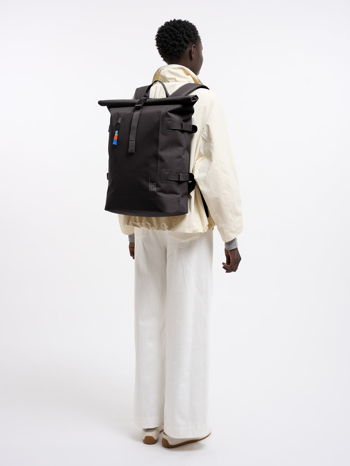 ROLLTOP Rucksack in mussel (dunkles Braun-Grau) von einer Frau als Rucksack auf dem Rücken getragen.