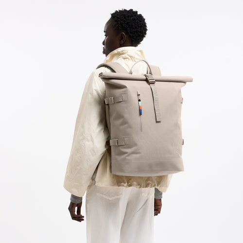 ROLLTOP Rucksack in scallop (helles Beige) von einer Frau auf dem Rücken getragen.