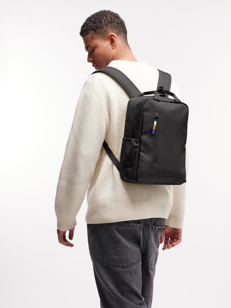 DAYPACK 2.0 Rucksack in mussel (dunkles Braun-Grau) von einem Mann auf dem Rücken getragen.