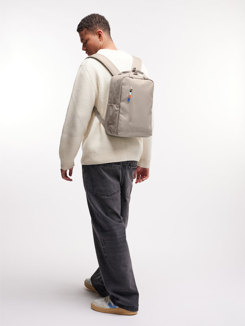 BP0023XX DAYPACK Rucksack in scallop (helles Beige) von einem Mann als Rucksack auf dem Rücken getragen.