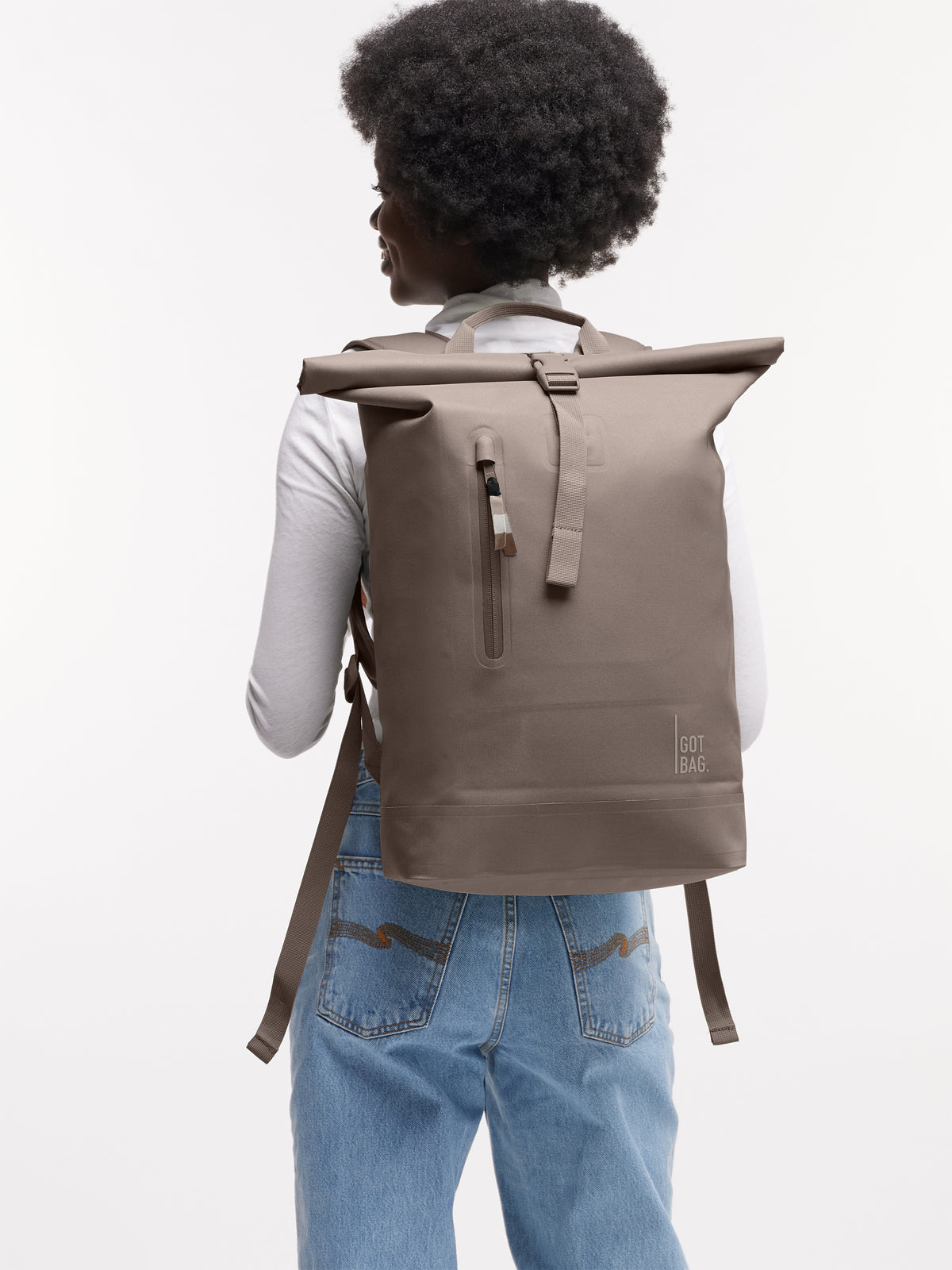 ROLLTOP LITE 2.0 MONOCHROME Rucksack in oyster (klassisches Taupe-Braun) von einer Frau auf dem Rücken getragen.