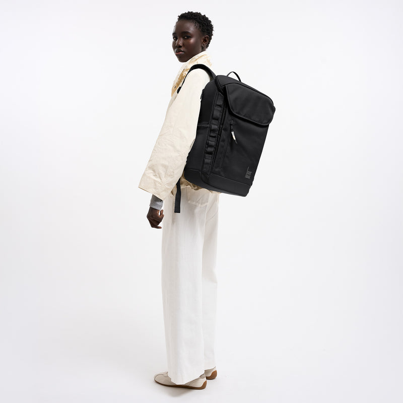 PRO PACK MONOCHROME Rucksack in black (Schwarz) von einer Frau als Rucksack auf dem Rücken getragen.