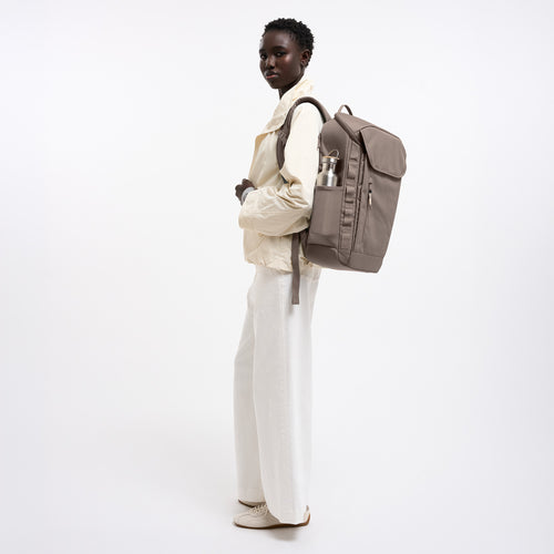 PRO PACK MONOCHROME Rucksack in oyster (klassisches Taupe-Braun) von einer Frau als Rucksack auf dem Rücken getragen.