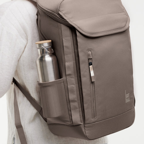 PRO PACK MONOCHROME Rucksack in oyster (klassisches Taupe-Braun) von einer Frau auf dem Rücken getragen.