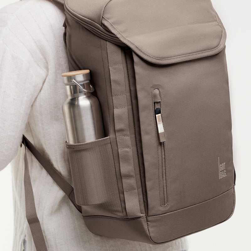 PRO PACK MONOCHROME Rucksack in oyster (klassisches Taupe-Braun) von einer Frau auf dem Rücken getragen.