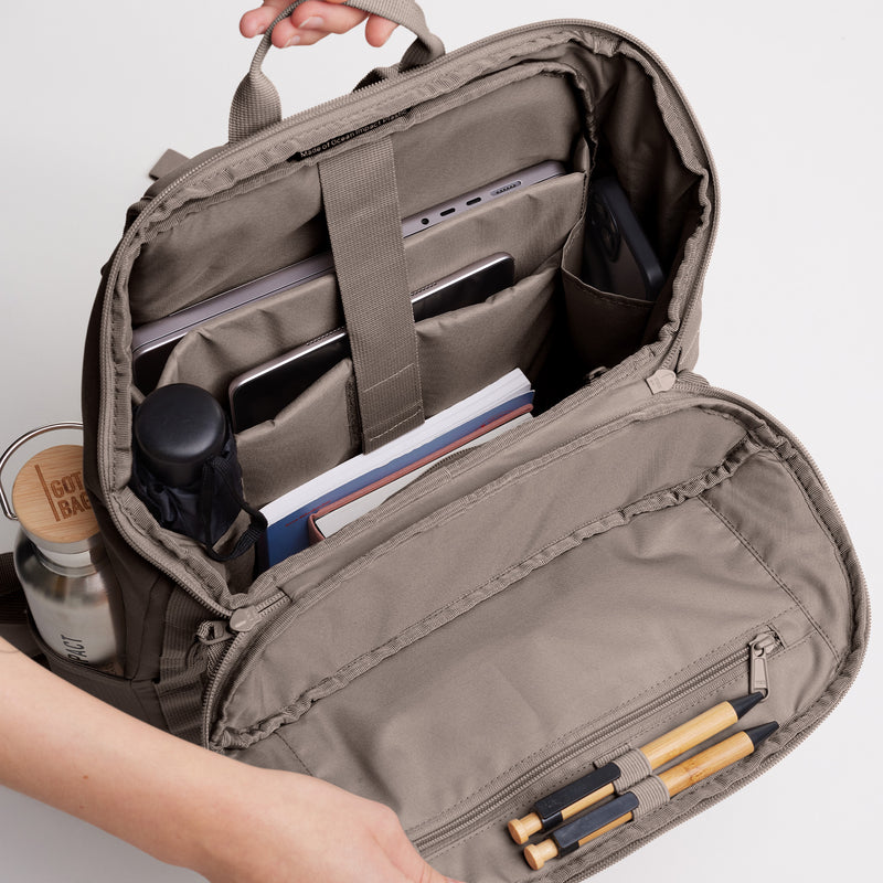 PRO PACK MONOCHROME Rucksack in oyster (klassisches Taupe-Braun), Innenansicht mit Laptop, Tablet, Flasche, Büchern und Stiften.