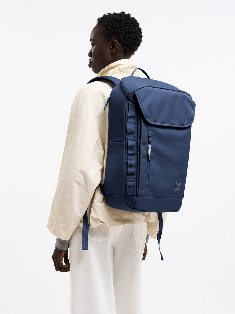 PRO PACK MONOCHROME Rucksack in deep ocean (dunkles Marineblau) von einer Frau auf dem Rücken getragen.