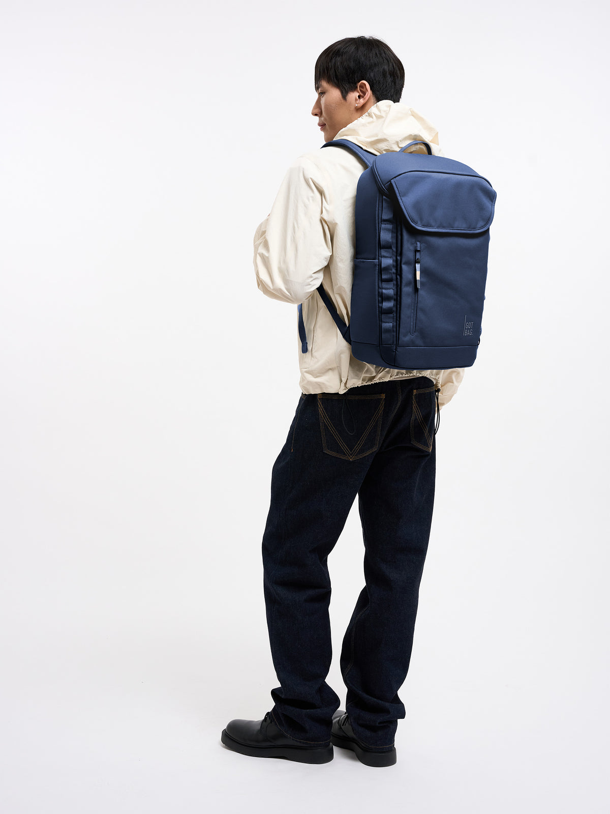 PRO PACK MONOCHROME Rucksack in deep ocean (dunkles Marineblau) von einem Mann als Rucksack auf dem Rücken getragen.