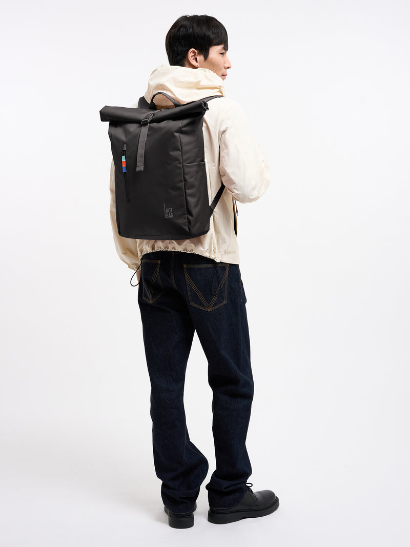 ROLLTOP EASY Rucksack in mussel (dunkles Braun-Grau) von einem Mann als Rucksack auf dem Rücken getragen.