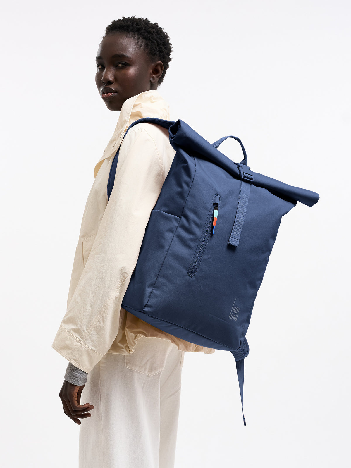 ROLLTOP EASY Rucksack in deep ocean (dunkles Marineblau) von einer Frau als Rucksack auf dem Rücken getragen.