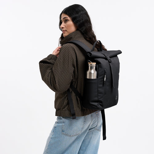 ROLLTOP EASY SMALL MONOCHROME Rucksack in black (Schwarz) von einer Frau als Rucksack auf dem Rücken getragen, mit Trinkflasche.