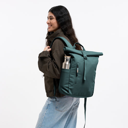 ROLLTOP EASY SMALL MONOCHROME Rucksack in sea teal (kühles Türkisgrün) von einer Frau als Rucksack auf dem Rücken getragen.