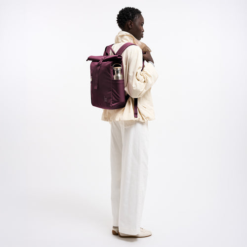 ROLLTOP EASY SMALL MONOCHROME Rucksack in kraken (Weinrot) von einer Frau auf dem Rücken getragen.