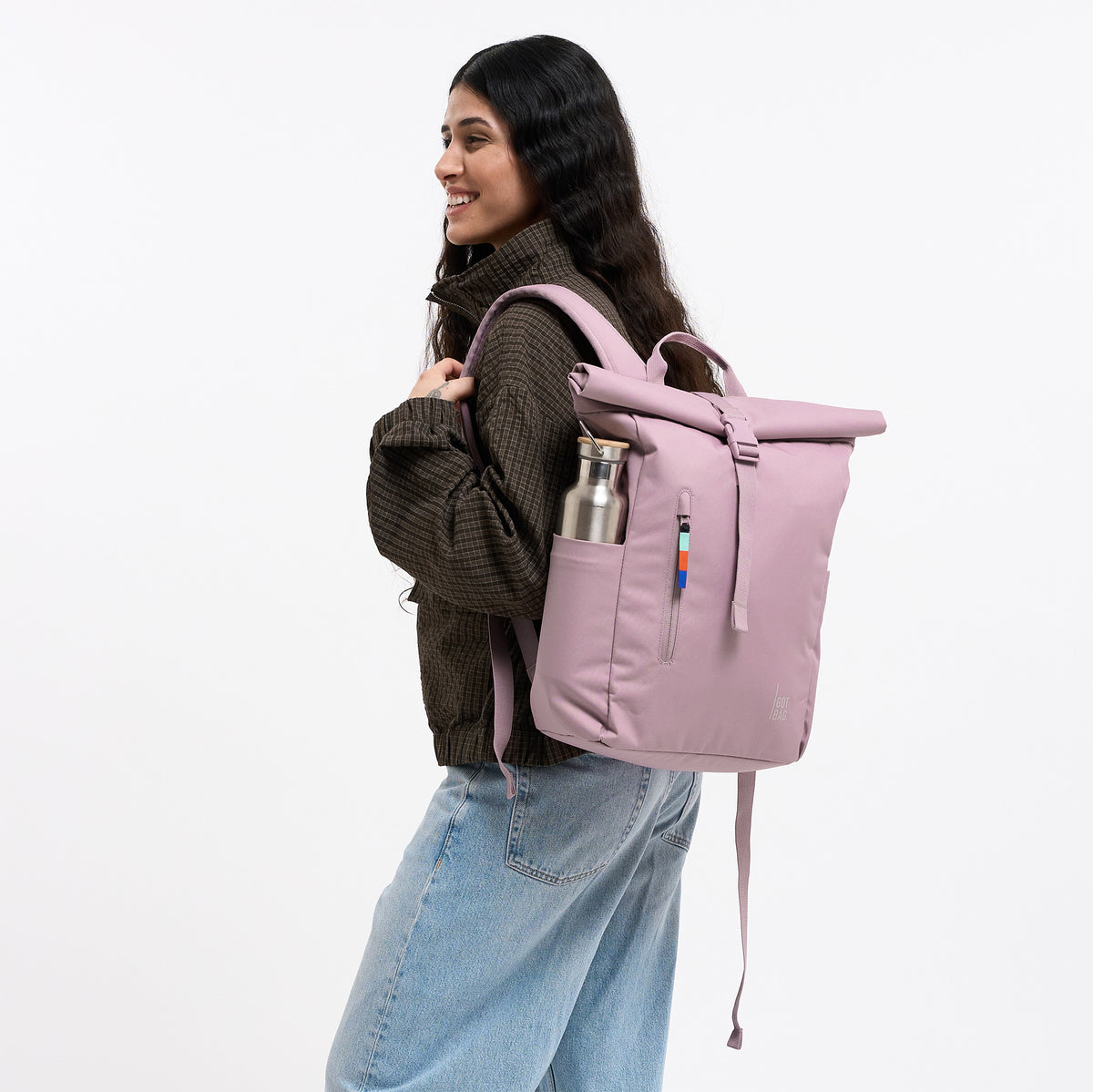 ROLLTOP EASY SMALL Rucksack in calamary (Altrosa) von einer Frau getragen, mit einer Trinkflasche in der Seitentasche.