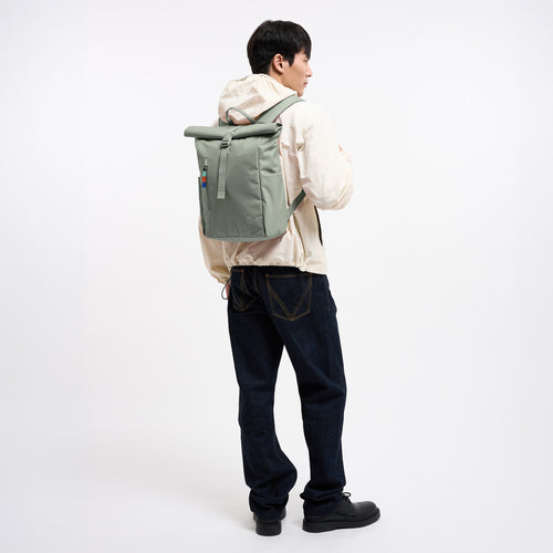 ROLLTOP EASY SMALL Rucksack in bass (Salbeigrün) von einem Mann auf dem Rücken getragen.