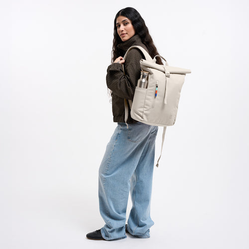 ROLLTOP EASY SMALL Rucksack in soft shell (warmes Cremeweiß) von einer Frau auf dem Rücken getragen.