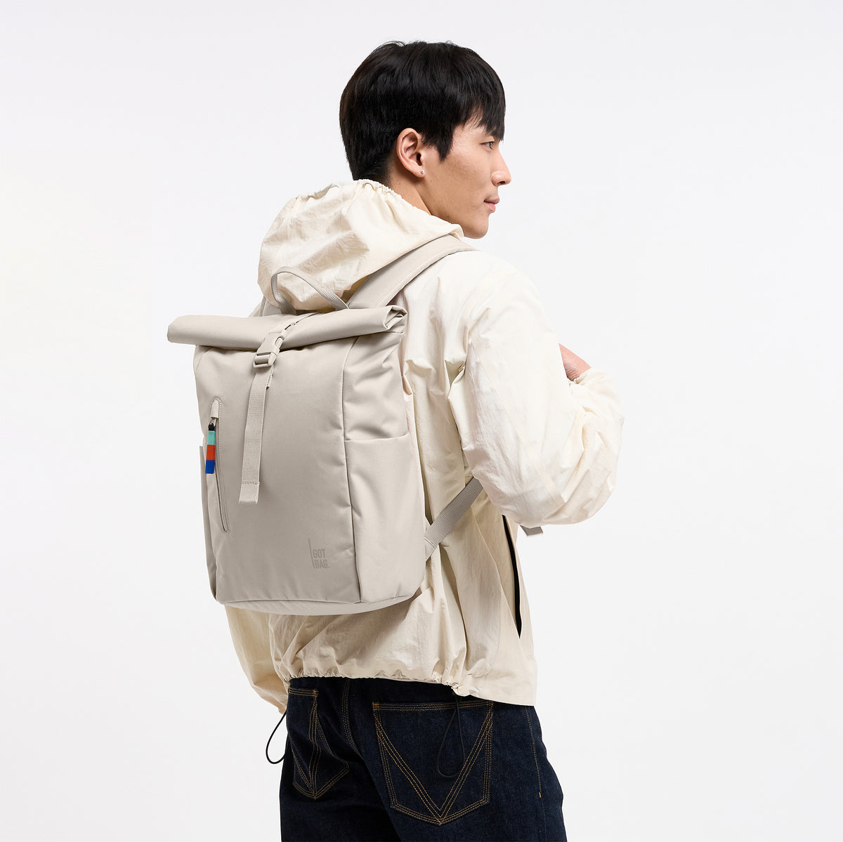 ROLLTOP EASY SMALL Rucksack in soft shell (warmes Cremeweiß) von einem Mann auf dem Rücken getragen.