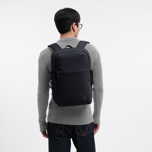 COMMUTER PACK Rucksack in black (Schwarz) von einem Mann auf dem Rücken getragen.