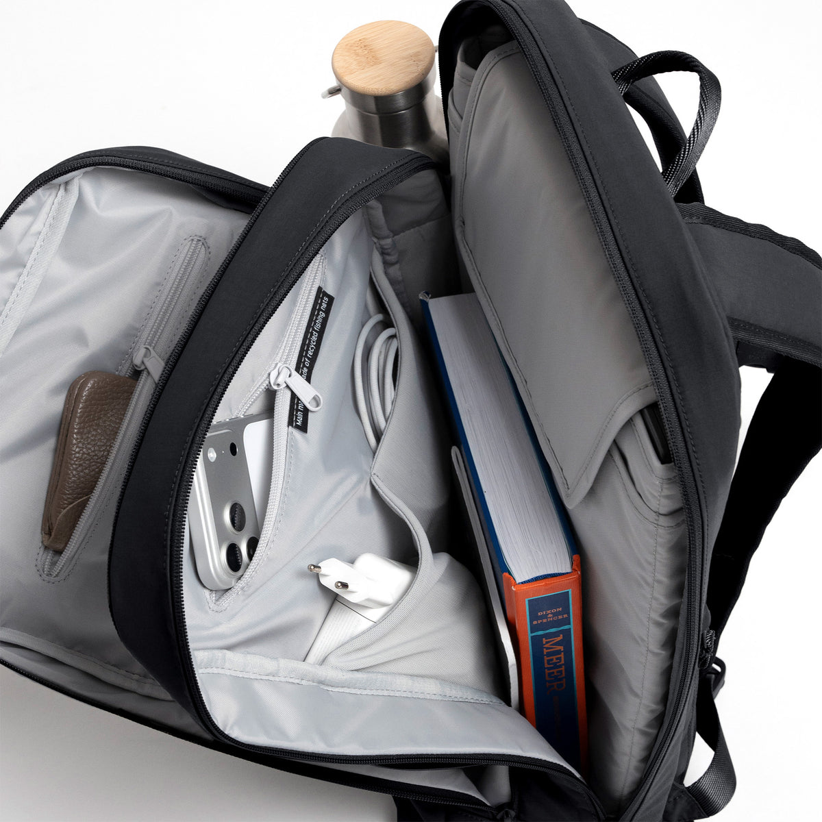 COMMUTER PACK Rucksack in shark (Dunkelgrau) mit geöffneter Innenansicht gefüllt mit Gegenständen.