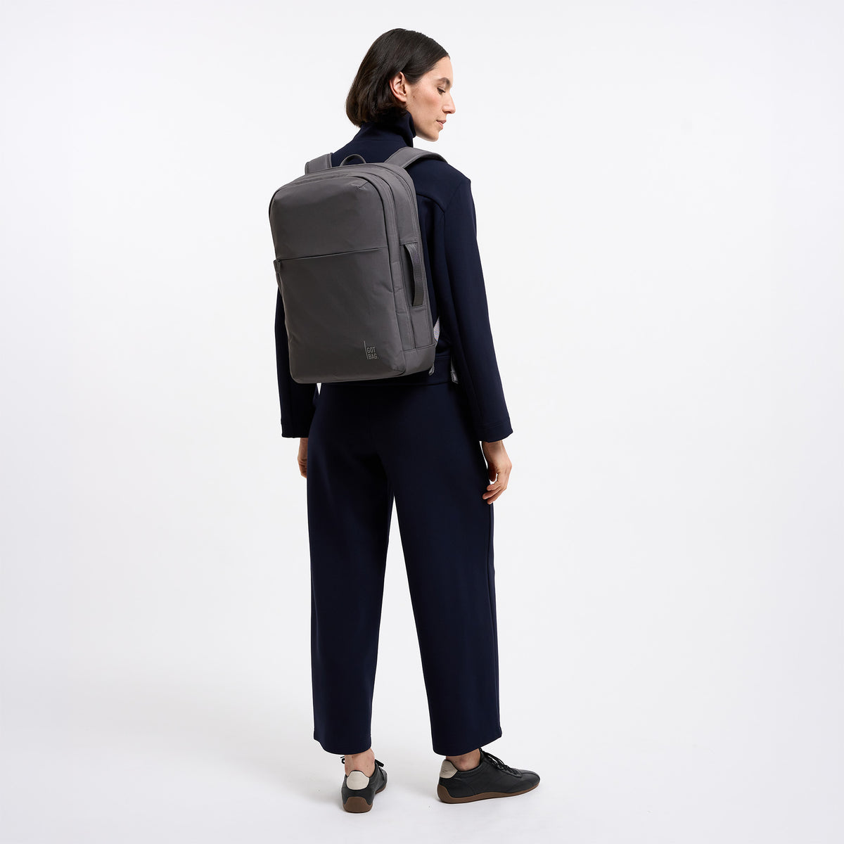 COMMUTER PACK Rucksack in shark (Dunkelgrau) von einer Frau als Rucksack auf dem Rücken getragen.