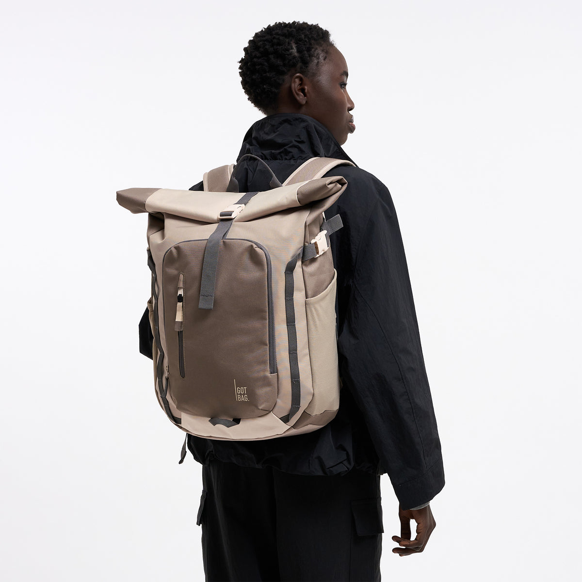 ROLLTOP ADVENTURE MONOCHROME Rucksack in oyster (klassisches Taupe-Braun) von einer Frau als Rucksack auf dem Rücken getragen.