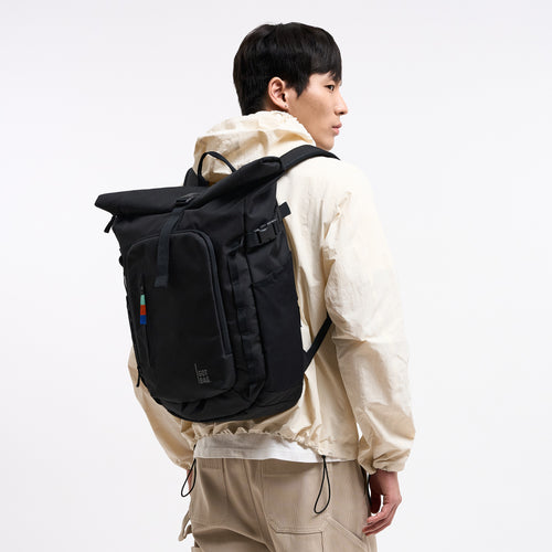 ROLLTOP ADVENTURE Rucksack in black (Schwarz) von einem Mann als Rucksack auf dem Rücken getragen.