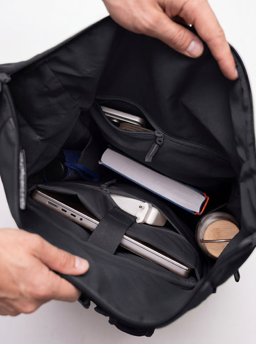 ROLLTOP ADVENTURE Rucksack in black (Schwarz), gefüllte Innenansicht mit Händen.