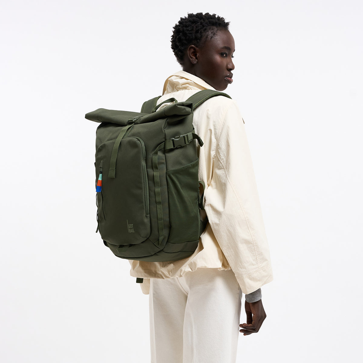 ROLLTOP ADVENTURE Rucksack in algae (Dunkelgrün mit Graustich) von einer Frau als Rucksack auf dem Rücken getragen.