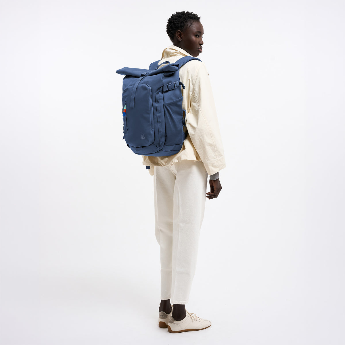 ROLLTOP ADVENTURE Rucksack in ocean blue (Marineblau) von einer Frau als Rucksack auf dem Rücken getragen.