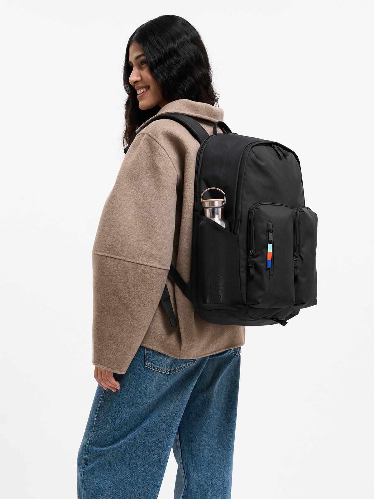 BASE PACK Rucksack in black (Schwarz) von einer Frau auf dem Rücken getragen.