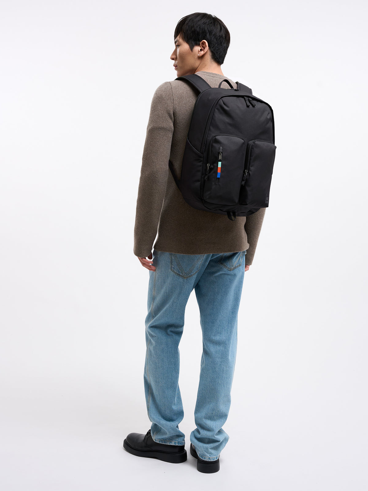 BASE PACK Rucksack in black (Schwarz) von einem Mann auf dem Rücken getragen.