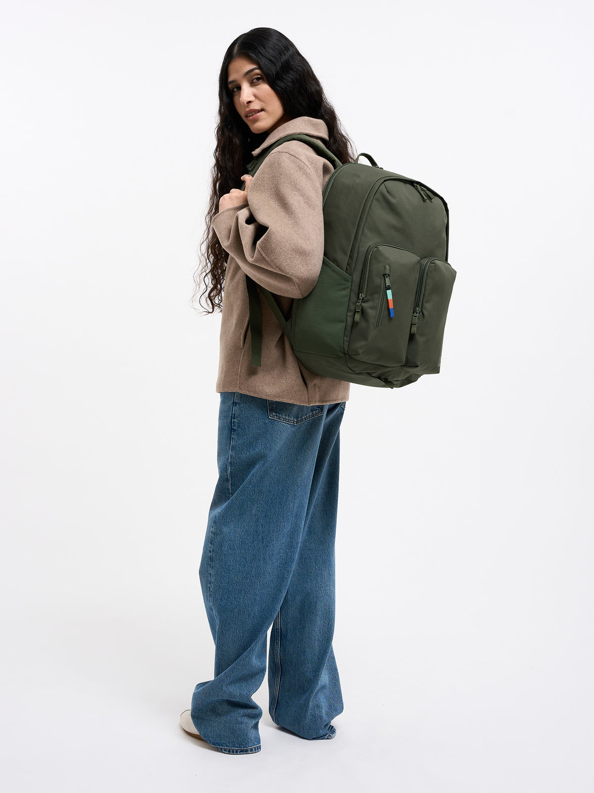 BASE PACK Rucksack in algae (Dunkelgrün mit Graustich) von einer Frau auf dem Rücken getragen.