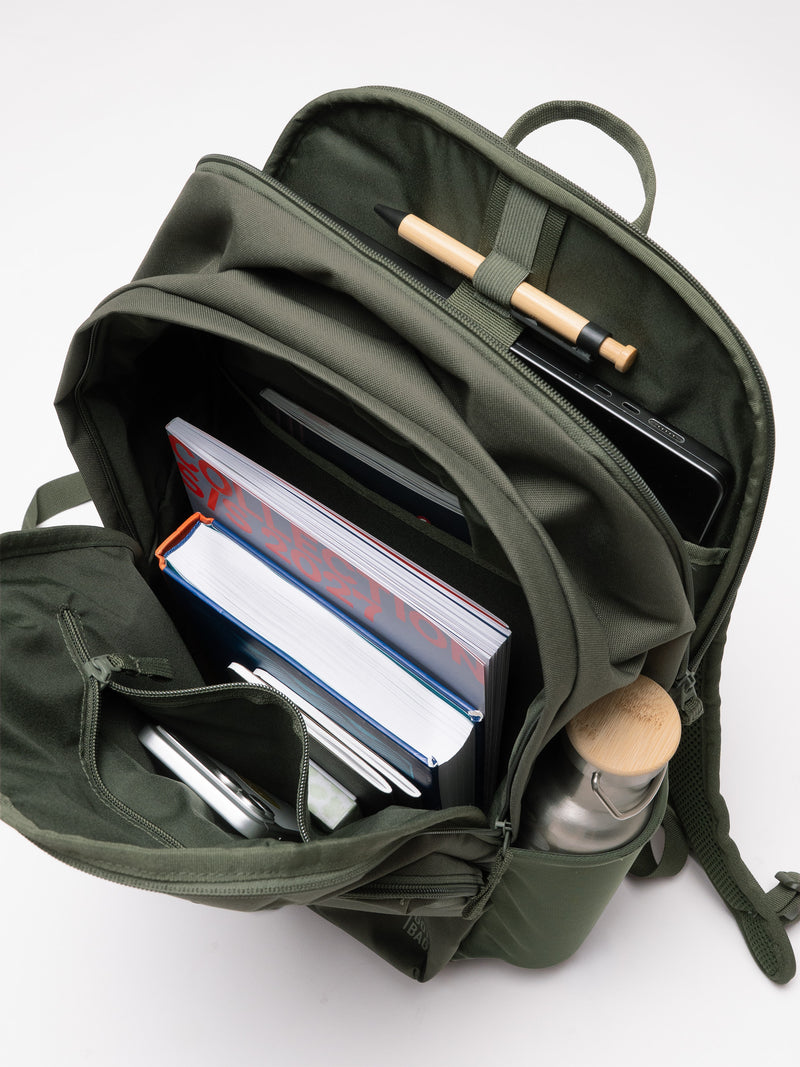 BASE PACK Rucksack in algae (Dunkelgrün mit Graustich) von oben, gefüllt mit Büchern, Handy und Flasche.