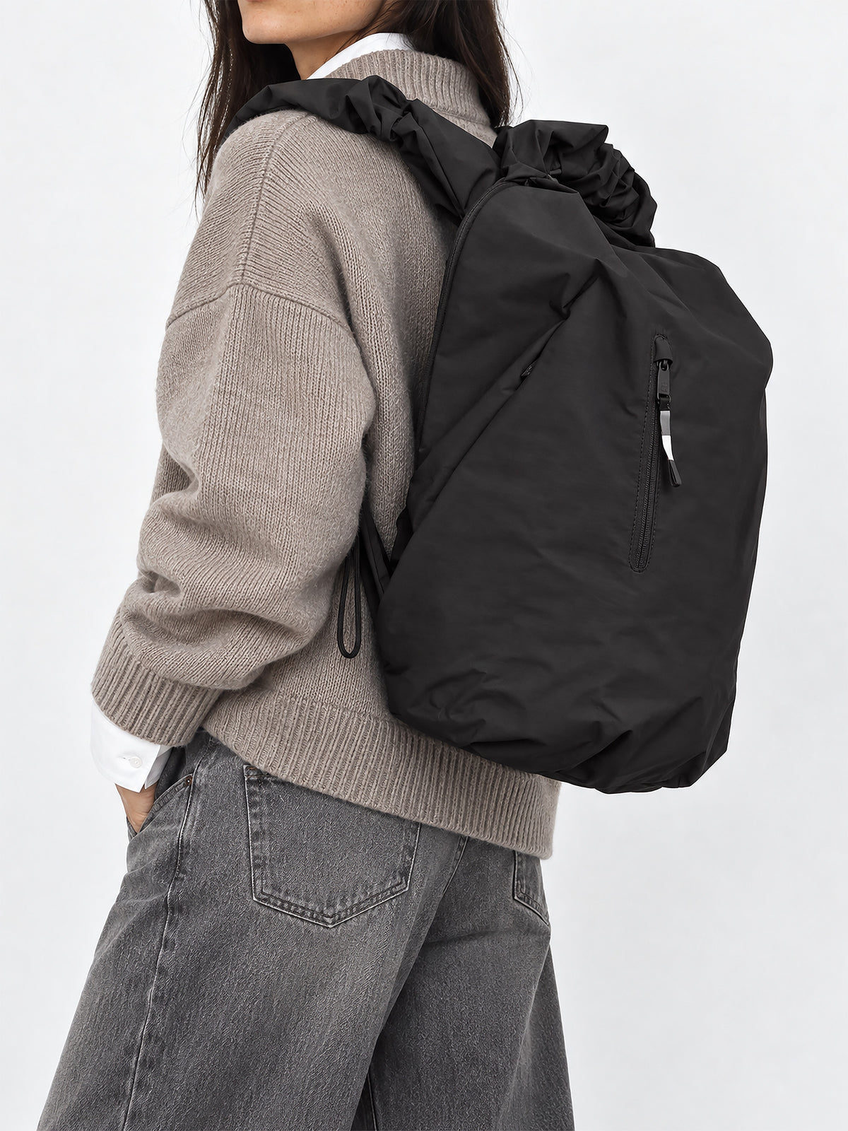 RUFFLE PACK Rucksack in black (Schwarz) von einer Frau auf dem Rücken getragen.