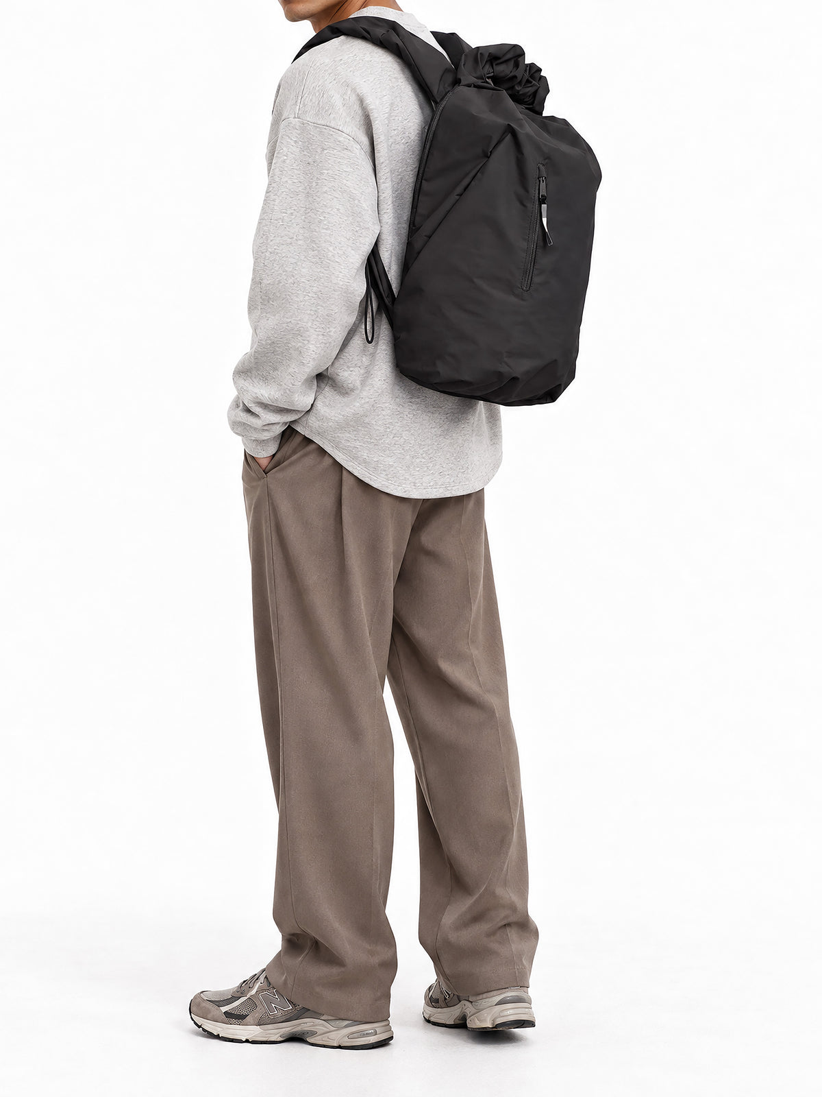 RUFFLE PACK Rucksack in black (Schwarz) von einem Mann auf dem Rücken getragen.