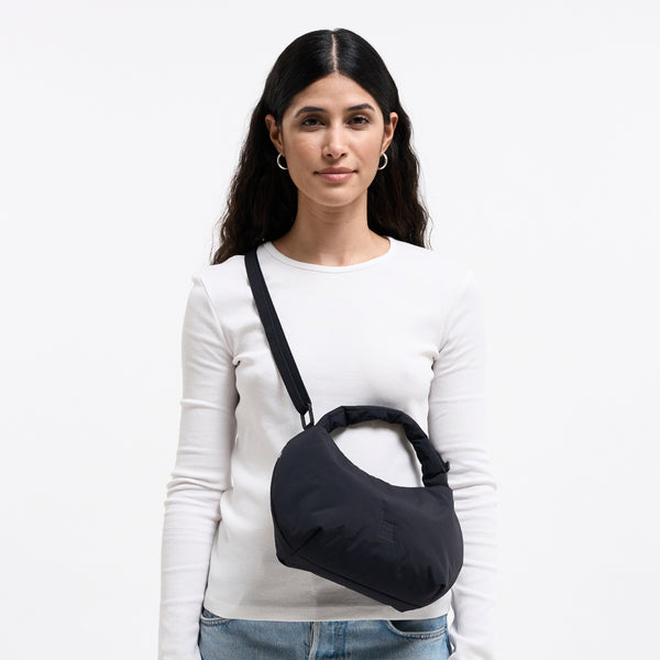 CLOUD BEAD BAG Tasche in black (Schwarz) von einer Frau crossbody getragen.