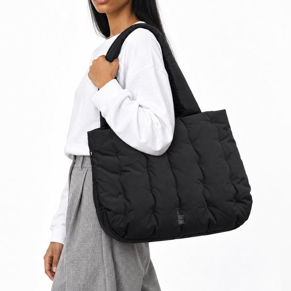 LOOMI HORIZON TOTE BAG Tasche in black (Schwarz) von einer Frau über der Schulter getragen.