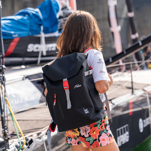 MALIZIA PACK Rucksack in black (Schwarz) von einer Frau als Rucksack auf dem Rücken getragen.