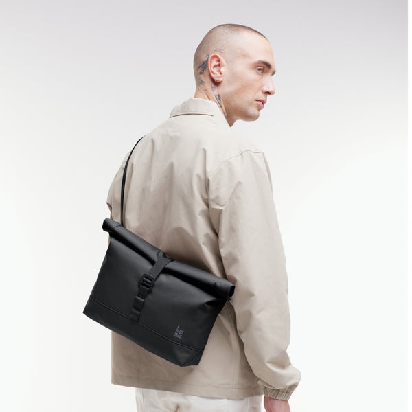 MESSENGER BAG Tasche in black (Schwarz) von einem Mann crossbody getragen.