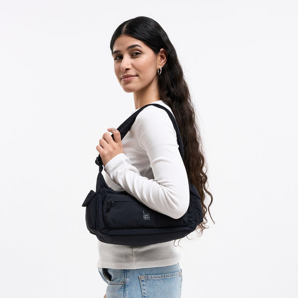 POCKET BAG SMALL Tasche in black (Schwarz) von einer Frau über der Schulter getragen.