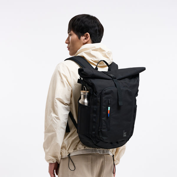 ROLLTOP ADVENTURE Rucksack in black (Schwarz) von einem Mann als Rucksack auf dem Rücken getragen.