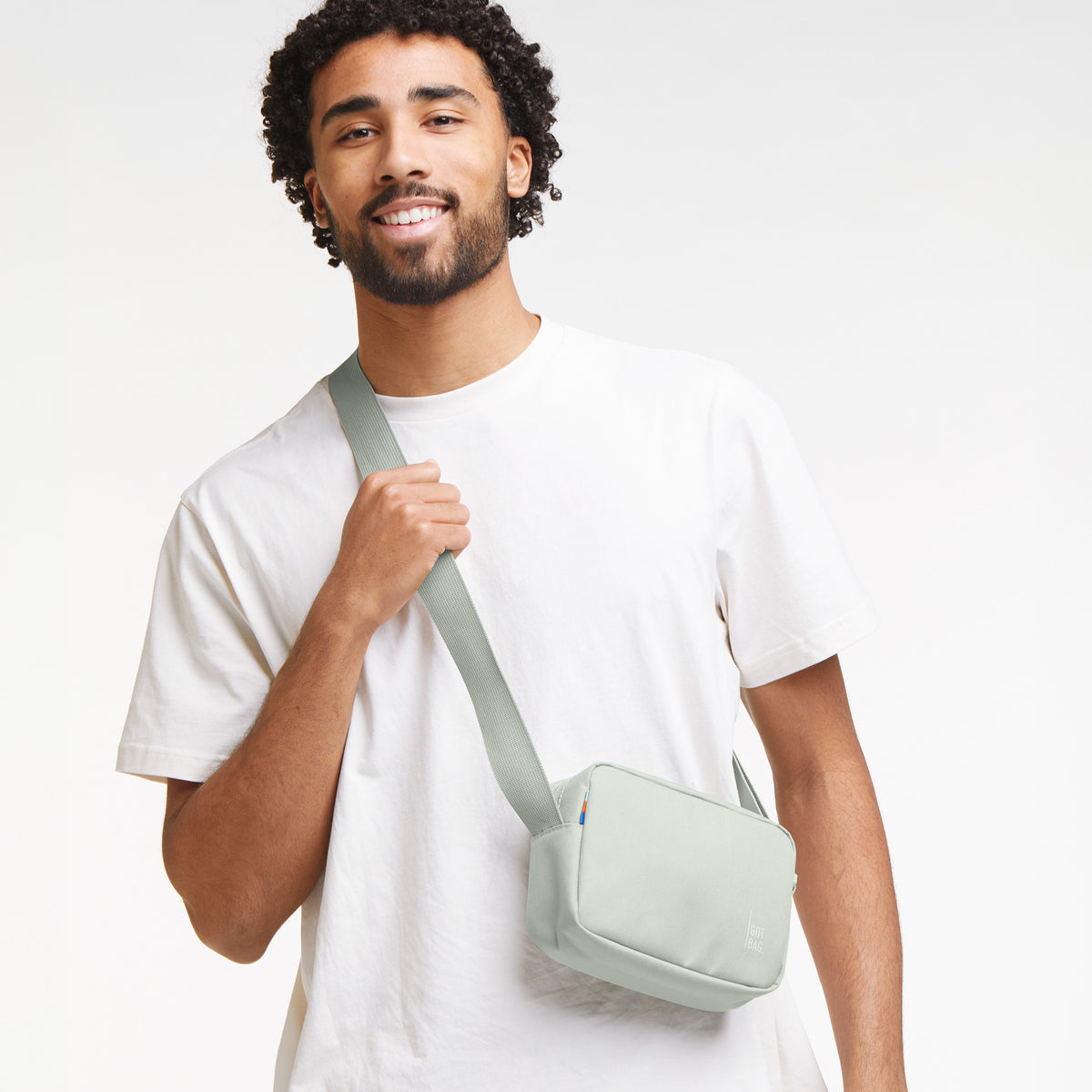 CROSSBODY BAG Tasche in eel (sehr helles Grün/Mint) von einem Mann crossbody getragen.